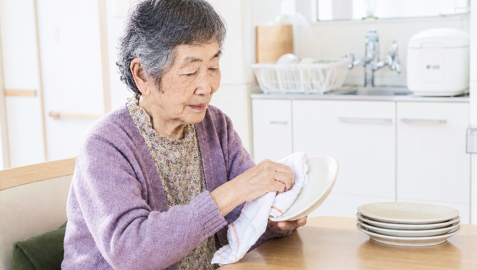 食器を拭く高齢女性